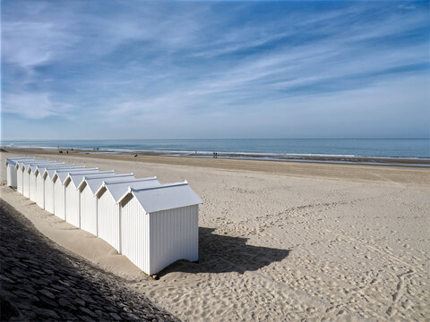 White beach cabins on the beach of Fort Mahon, a commune in the Somme department in Hauts-de-France in northern France.  