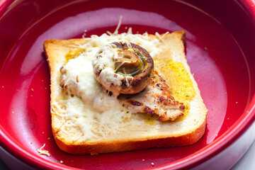 slice of  toast bread grilled with meat, champignon and cheese