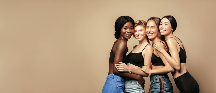 Multi Ethnic Group of Womans with diffrent types of skin standing together and looking on camera. Diverse ethnicity women - Caucasian, African and Asian against beige background