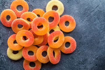 Top down view of vibrant sugar coated peach flavoured gummy rings.
