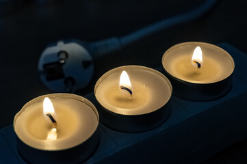 Stromausfall/Blackout - Teelicht und Stromstecker - Energiekrise 2022 in Deutschland