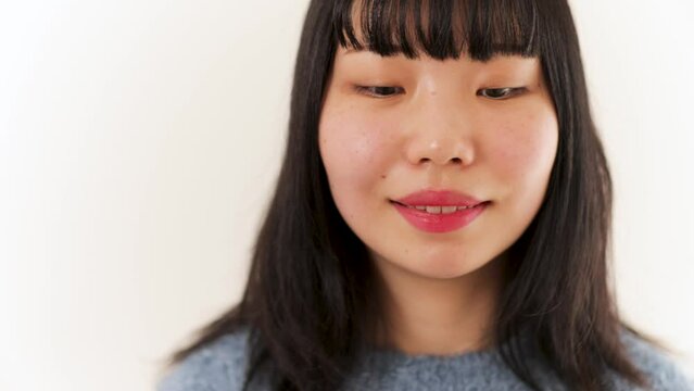 Young shy Japanese woman smiles.Close up.  4K25p