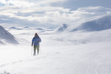 Fototapeta na wymiar Snow shoe hiking on a sunny day in the mountains of Dovrefjell National Park