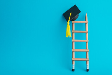 Graduation cap on top of pencil ladder with blue background copy space. Business education, scholarship, abroad educational and goal or target successful graduation concept. © pla2na