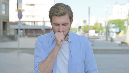 Young Man Coughing while Standing Outdoor