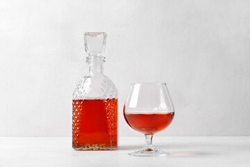 Cognac in a glass and decanter. Strong alcoholic drink on white