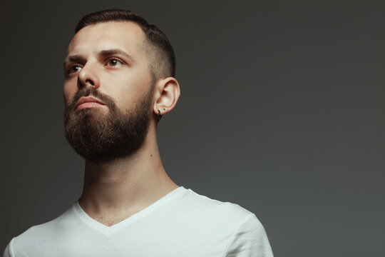 Male Beauty Concept. Portrait Of Proud Charismatic Active 30-year-old Man Posing Over Dark Gray Background. Perfect Haircut. Hipster Style. Close Up. Copy-space. Studio Shot