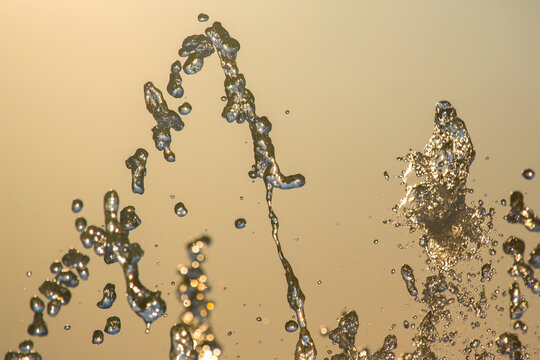 drops of the fountain in the setting sun