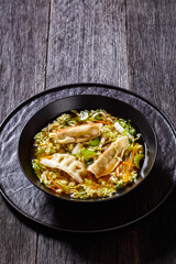 Asian Gyoza Soup in black bowl, top view