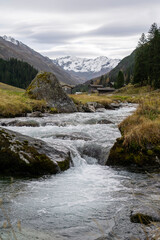 Small river in the foreground of mountains of Davos in autumn, Switzerland  