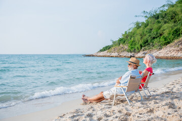 Fototapeta na wymiar Senior couple relaxing and spend time together at tropical beach., Healthy seniors lifestyle concept.
