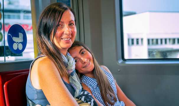 Happy Young Girl In The Subway Train Smiling With Her Mother