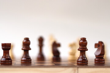 A chessboard with walking figures placed on a white background. Strategy game.