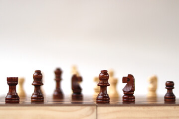 A chessboard with walking figures placed on a white background. Strategy game.