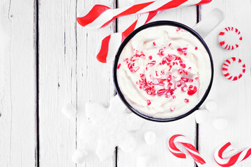 Christmas candy cane hot chocolate. Top down table scene with peppermints against a white wood...