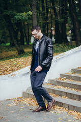 Fototapeta premium a man in a leather jacket comes down the stairs