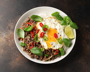 Stir Fried Pad Kra Pao with rice and egg in white plate