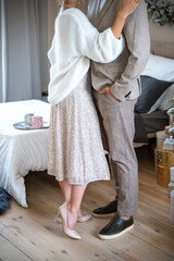 Obraz premium Romantic couple standing near Christmas tree at home and hugging