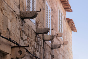 Details of walls, roof tiles and windows of yellow, orange and brown houses as seen in sunny day in...