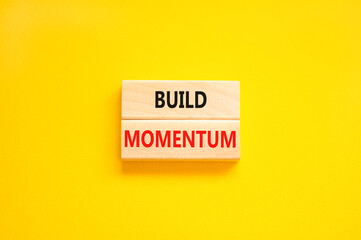 Build momentum symbol. Concept words Build momentum on wooden blocks. Beautiful yellow table yellow background. Business and build momentum concept. Copy space.