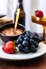 Tábua de doces com doce de leite, uva, morango, croissant, donut e drink