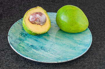 A fruta abacate representada natural e cortada, de excelentes propriedades que ajudam na saúde e...