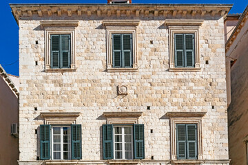 Details of walls and windows of yellow, orange and brown houses as seen in sunny day in Dubrovnik, Croatia. September, daytime. Abstract vintage or travel background.