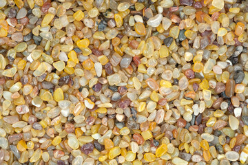 Full frame of Yellow Agate gemstone particles. Decorative Stone pebbles for coating in the Aquarium or garden. Extreme close up of heap, top view