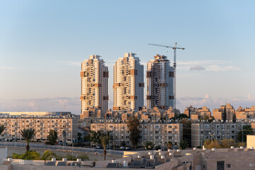 Typical architecture in Israel. Contrast in four generations of buildings. finishing modern tower skyscrapers near aged old buildings in Be’er Sheva Old and new development architecture concept.