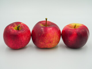 Three red apples arranged in a line