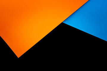 Arrière plan avec papiers colorés superposés, orange, bleu et noir