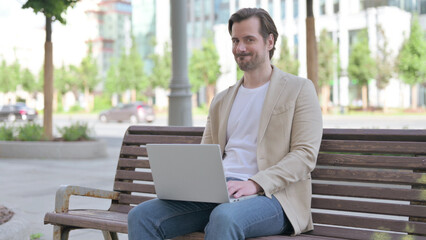 Rejecting Young Man in Denial While using Laptop Sitting on Bench