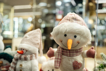 Christmas concept. A snowman stands in a shop window with a smile and creates a festive mood.