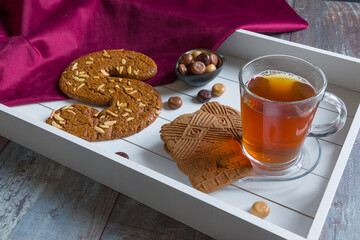 A cup of tea and spiced bisquit on a tray