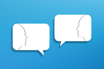 Dialog concept. Speech bubbles with two faces on blue background.