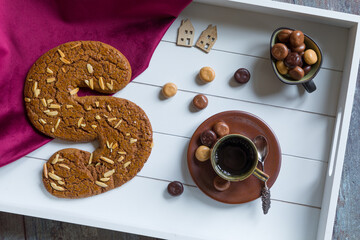 A cup of coffee and spiced bisquit on a tray