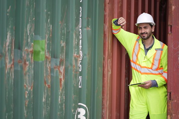 Dock worker man in safety vest work in container port terminal. male Industrial Engineer in Hard Hat, High-Visibility Vest Working. Inspector or Safety Supervisor in Container Terminal. shipping yard.