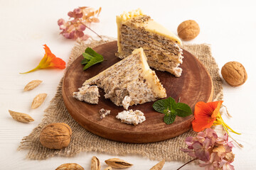 Fototapeta na wymiar Walnut and almond cake on white wooden, side view