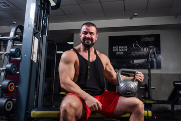 Fototapeta na wymiar Strong man is training in the gym