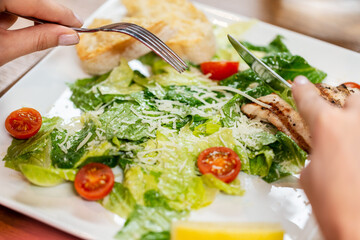 food, people and leisure concept - close up of woman with fork eating at restaurant
