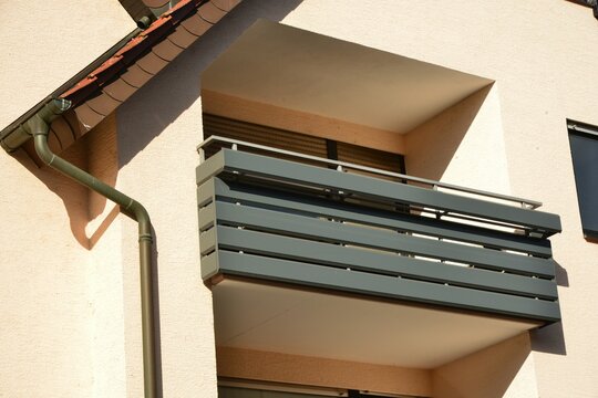 Moderne Balkone mit Sichtschutz aus beschichteten Aluminiumelementen und Metall-Geländer an Neubau-Hausfront