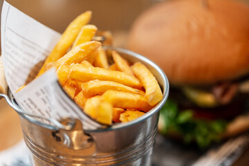 fast food, unhealthy eating and people concept - close up of french fries and burger at restaurant