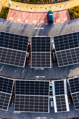 Aerial view of solar panels on a parking lot rooftop charging electric cars