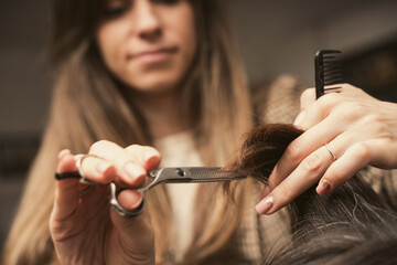 Hair care, beauty industry concept. Hairdresser doing haircut closeup of work. Hairstylist does...