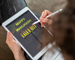 A Jewish boy draws a spin on a tablet for the holiday of Hanukkah