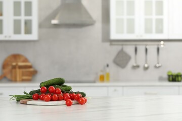 Fresh clean vegetables on white table in kitchen, space for text