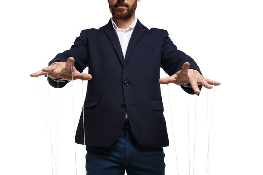 Man in suit pulling strings of puppet on white background, closeup
