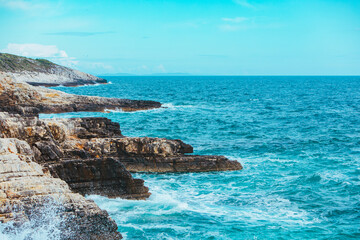 view of rocky seaside waves with white foam