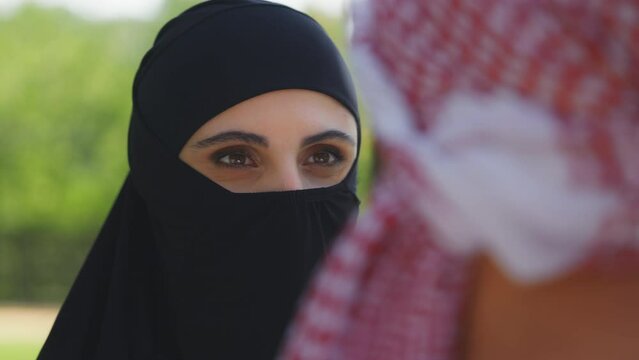 Young Arab woman in burqa listening to husband, Islamic family traditions