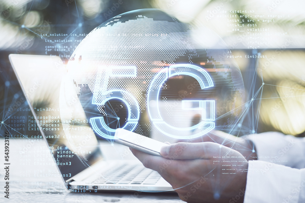 Poster male hands using laptop and cellphone at desk with glowing planet earth globe hologram with 5G and index graph on blurry background. Mobile internet network, speed and signal. Double exposure.